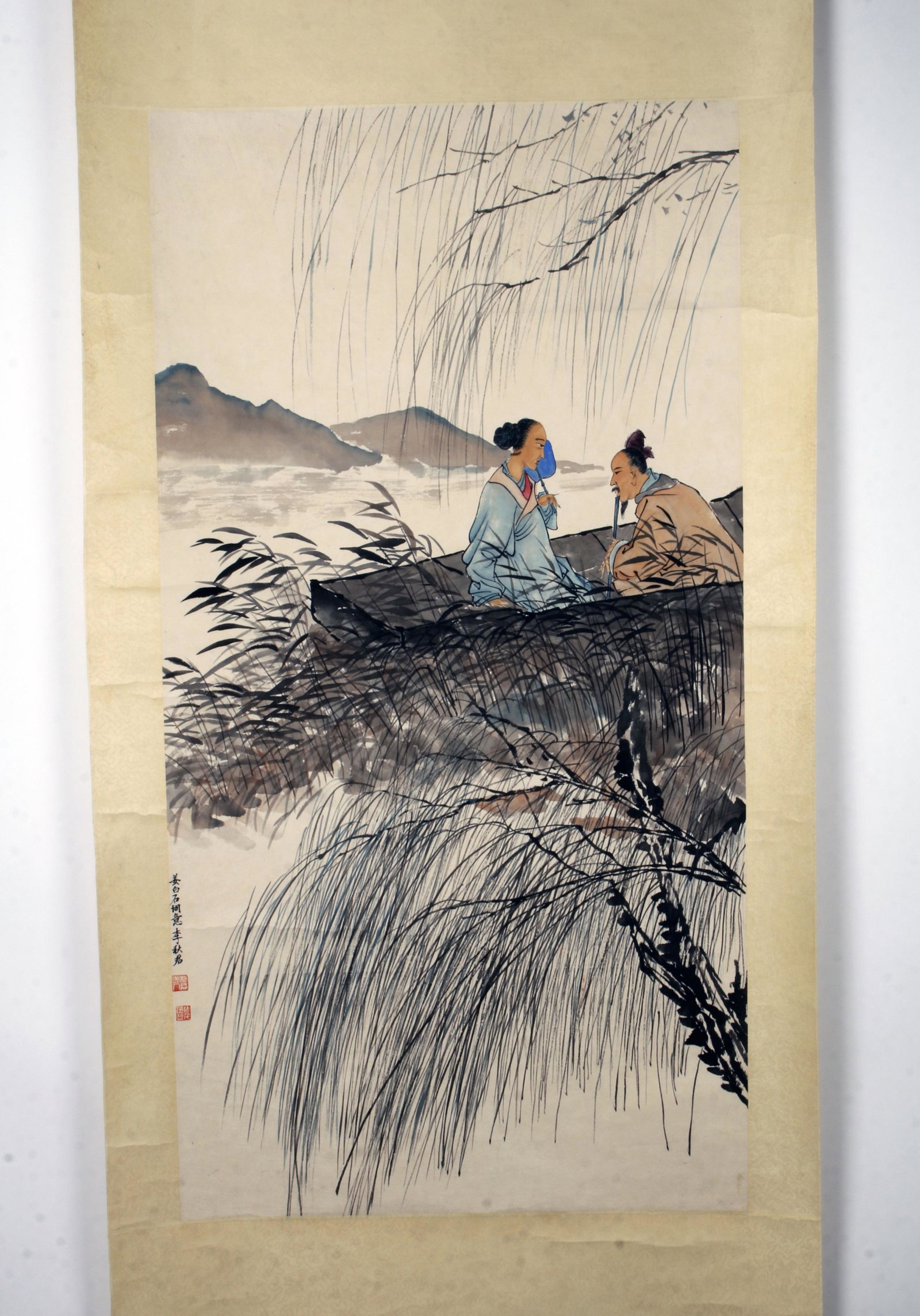 CHINESE SCROLL OF A COUPLE IN A BOAT: CHINESE SCROLL OF A COUPLE IN A BOAT A man and woman are in a boat on a river with wispy branched in the foreground. Calligr