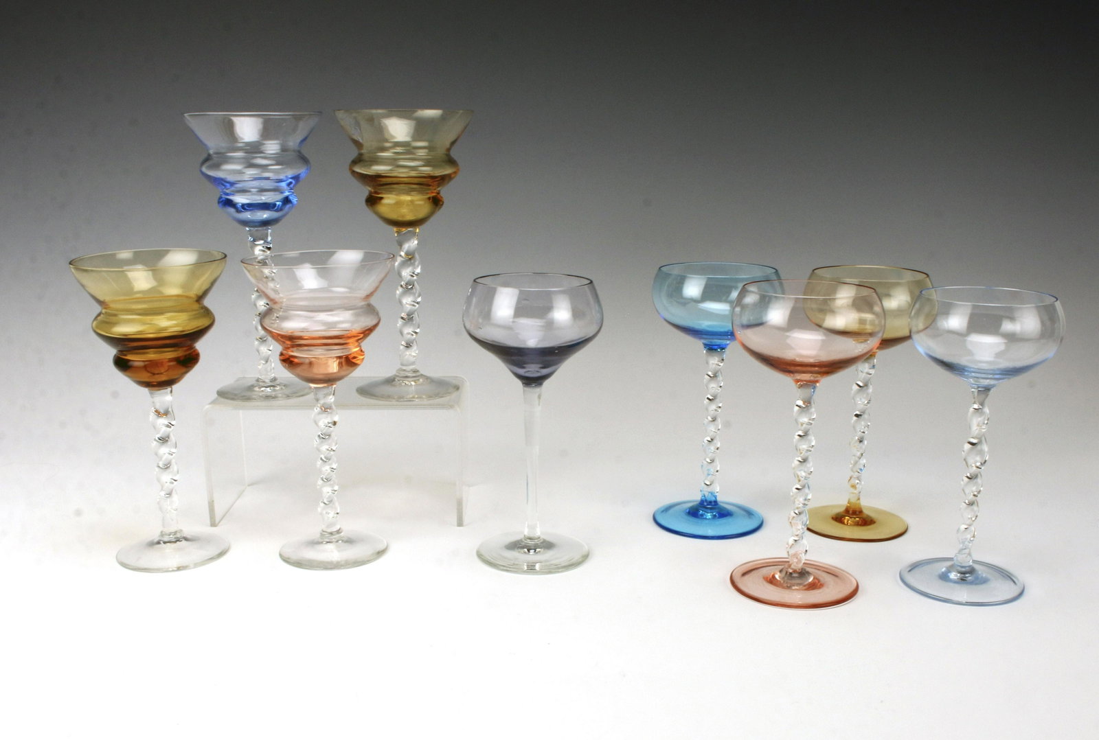 VINTAGE COLORFUL TWISTED STEM WINE GLASSES: VINTAGE COLORFUL TWISTED STEM WINE GLASSES Two sets of 4 wine glasses, both sets with twisted clear stems, and a single straight stem glass. 6 1/2"