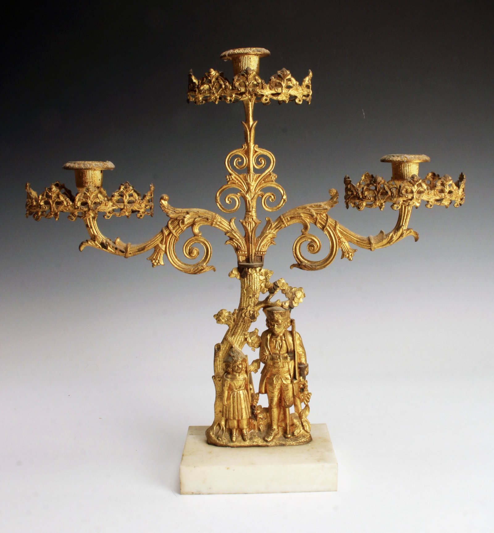 GILT BRONZE CANDELABRA: GILT BRONZE CANDELABRA A soldier stands next to a child at the base of a tree. The trunk grows above them to become the three arms of the candelabra. Elaborate metalwork, holds three can