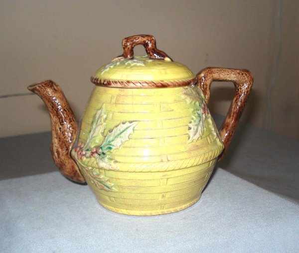 Majolica tea pot: A majolica tea pot in the Christmas theme, with a basket weave pattern and applied holly leaves and berries. 5 1/2"