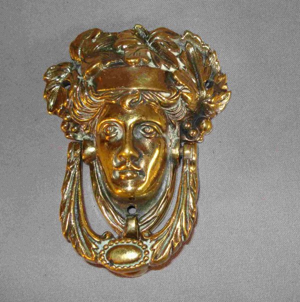 Brass door knocker: An antique solid brass door knocker, about 5-6", that may be mounted on interior door. The antique knocker shows a lady's face with a headband.