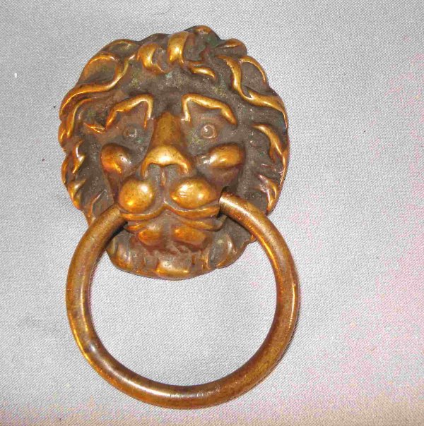 Lion's head door knocker: An antique solid brass door knocker, about 4 1/4", that may be mounted on interior door. This a lion with a ring through his mouth, about 5"