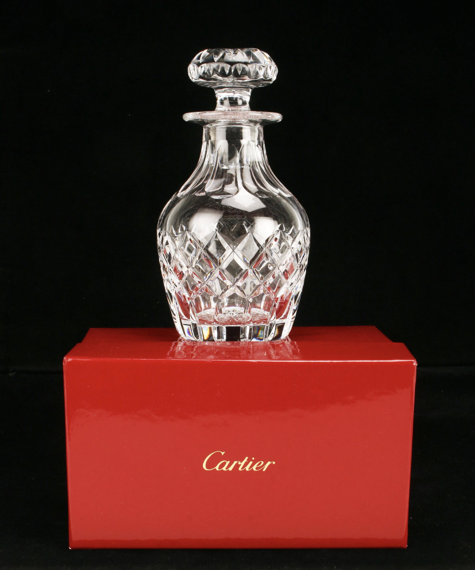 CARTIER CRYSTAL DECANTER IN BOX: CARTIER CRYSTAL DECANTER IN BOX Cut crystal decanter in red Cartier box. Marked Cartier on bottom. 7" x 4" Shipping: