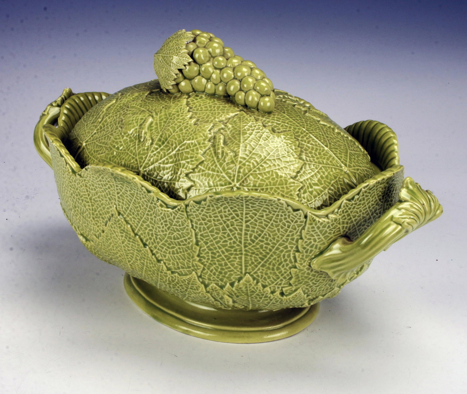 ITALIAN MAJOLICA GRAPE LEAF MOTIF TUREEN: ITALIAN MAJOLICA GRAPE LEAF MOTIF TUREEN Intricately molded overlapping leaves with grape bunch finial in bright light green glaze. Handles in stylized scrolling leaf design. Marked Made