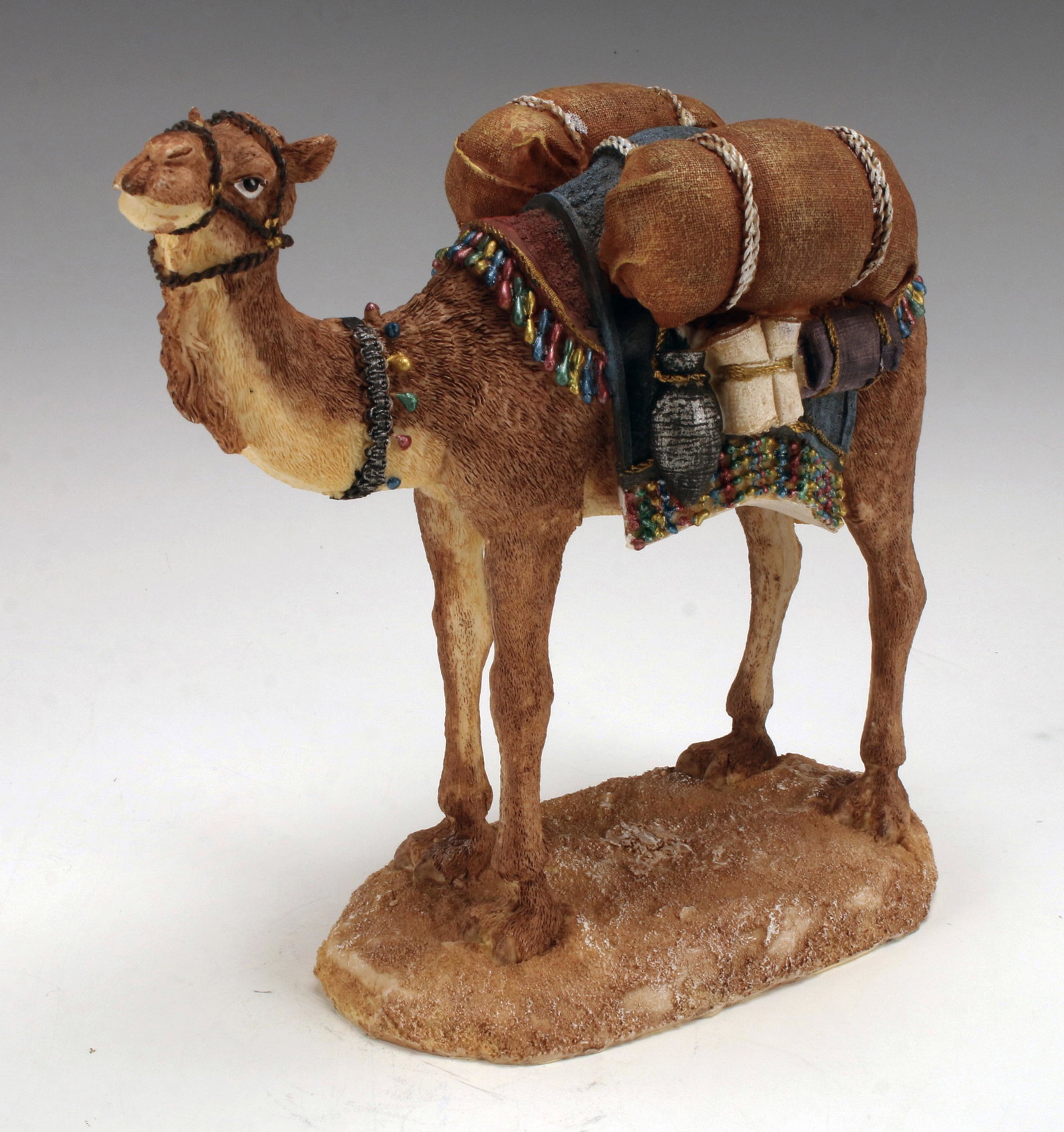 REALISTIC LOOKING RESIN CAMEL: REALISTIC LOOKING RESIN CAMEL Resin dromedary camel with texture and elaborate painted saddlebags and goods. 9 1/2" X 9 1/2"