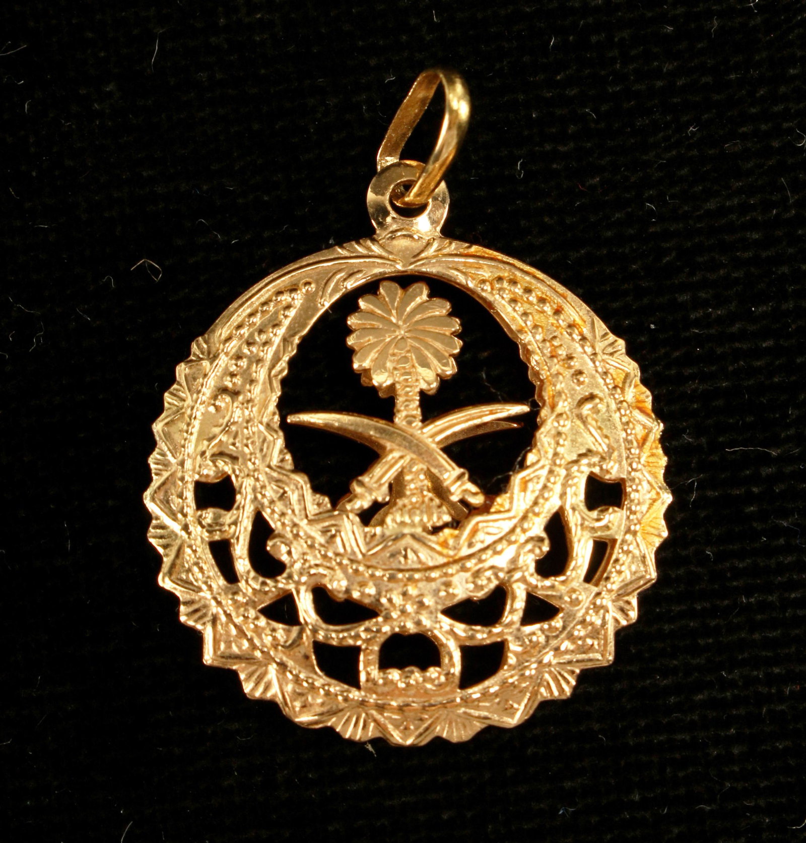 18K DOMED CIRCULAR FILIGREE OPENWORK PENDANT: 18K DOMED CIRCULAR FILIGREE OPENWORK PENDANT Circular filigree openwork pendant with Saudi Arabian seal of crossed swords below a palm tree. 7/8"