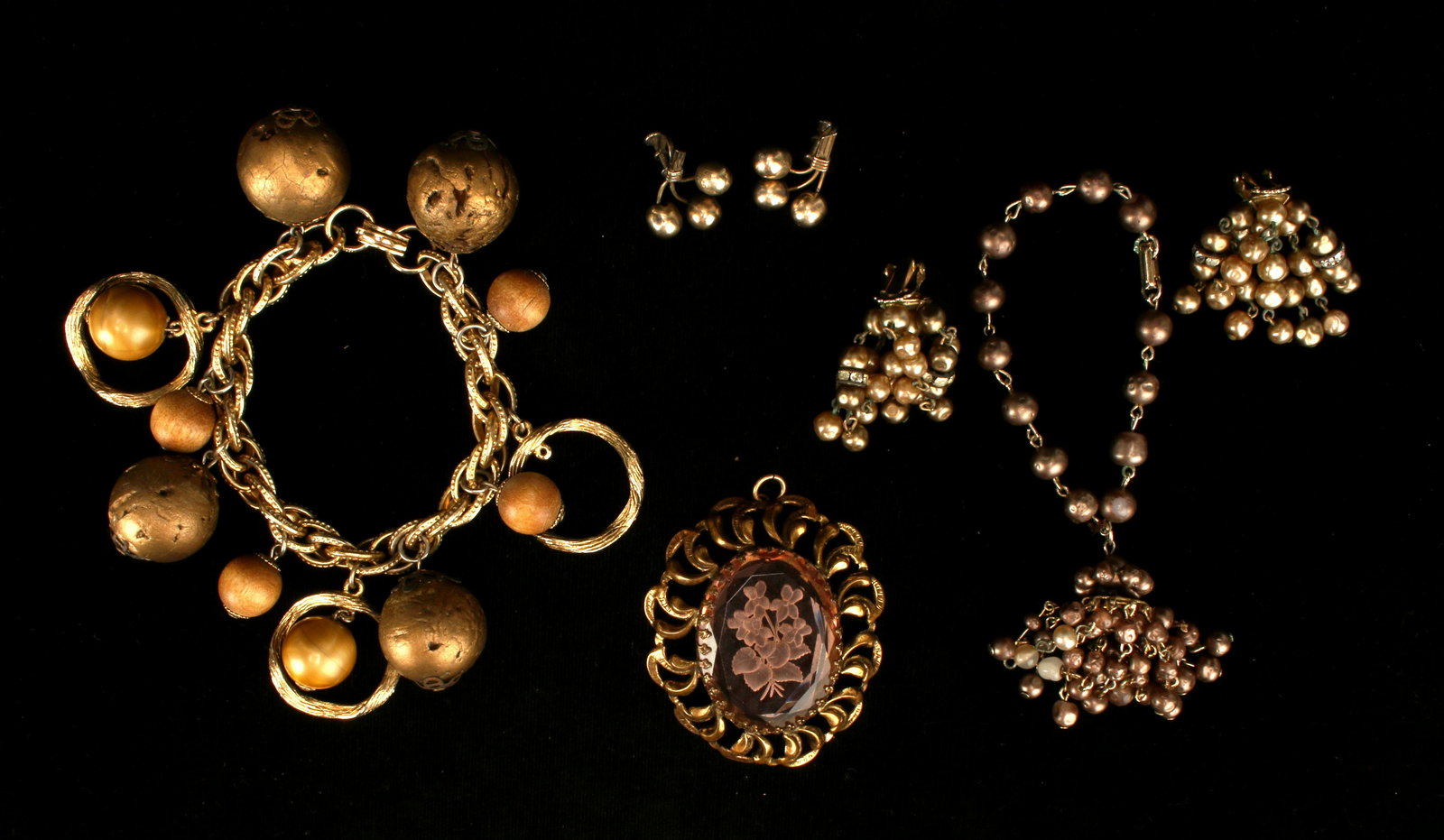 ANTIQUE LOOK BRONZY COSTUME JEWELRY LOT: ANTIQUE LOOK BRONZY COSTUME JEWELRY LOT Bronze colored faux pearl bead tassel bracelet & earrings, 3-ball brass earring pair, rose colored carved glass floral pendant, and chunky gol