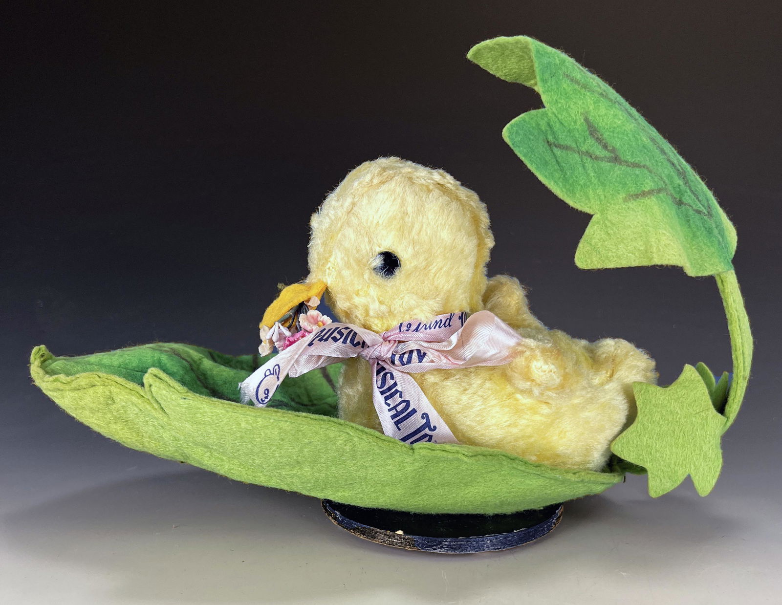 GUND MUSICAL WIND UP TOY DUCKY: GUND MUSICAL WIND UP TOY DUCKY A fuzzy duckling holding flowers in his beak and laying a giant leaf turns and plays Lullaby and Goodnight music when wound.