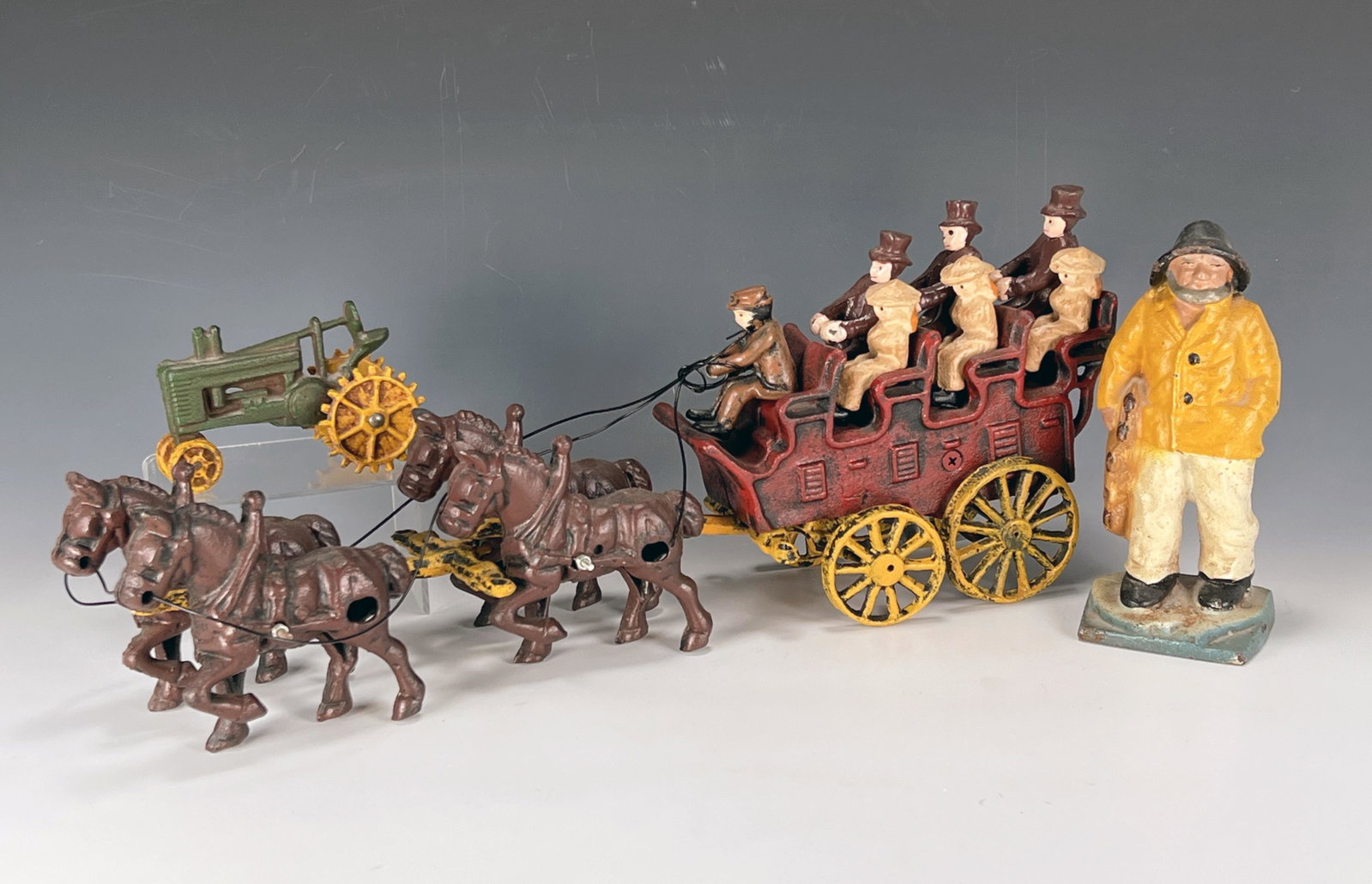 VINTAGE CAST IRON CARRIAGE & TRACTOR: VINTAGE CAST IRON CARRIAGE & TRACTOR Vintage cast iron carriage with 6 passengers and a coachman being pulled by 4 horses. Also includes a smaller vintage cast iron green and yello