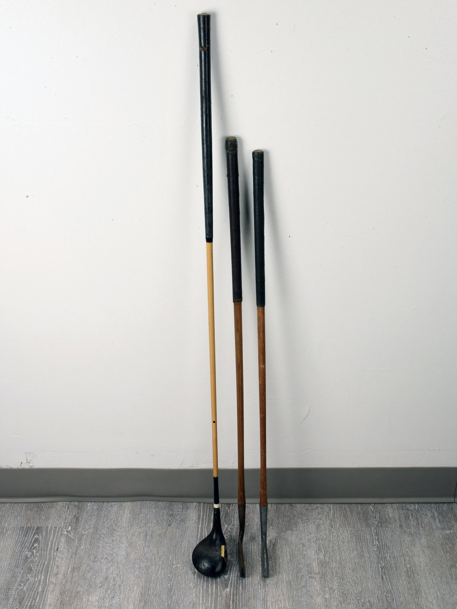 3 VINTAGE HICKORY SHAFTED GOLF CLUBS: 3 VINTAGE HICKORY SHAFTED GOLF CLUBS With bound leather grips, includes driver and two putters. 43 1/2" Shipping: