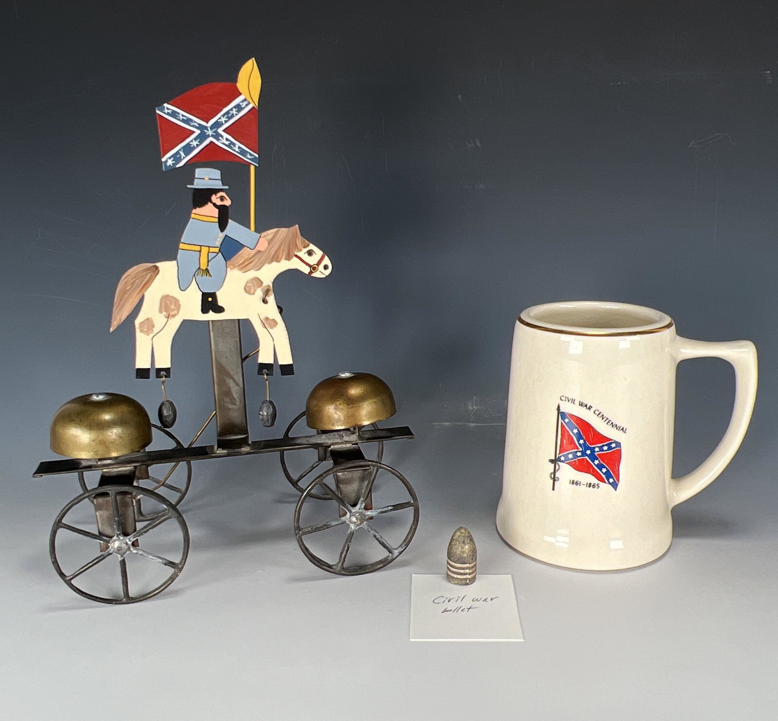 CONFEDERATE COLLECTIBLES AND CIVIL WAR BULLET: CONFEDERATE COLLECTIBLES AND CIVIL WAR BULLET Tin toy folk art by Mary and Dawson Gillaspy. Civil War Centennial mug marked Made in USA. Possible Civil War bullet. Converse Auc