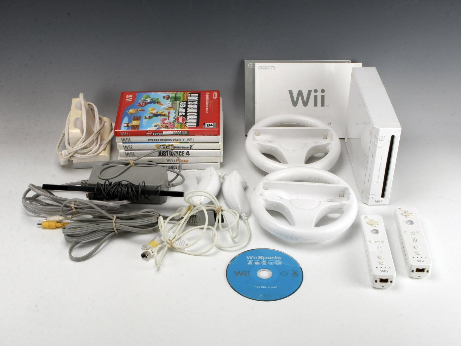 NINTENDO WII CONSOLE LOT TESTED WHITE RVL-001: NINTENDO WII CONSOLE LOT TESTED WHITE RVL-001 Includes 7 games, 2 controllers, 2 steering wheels, and a Wii-mote charging station. 10" x 5 1/5" x 2"<