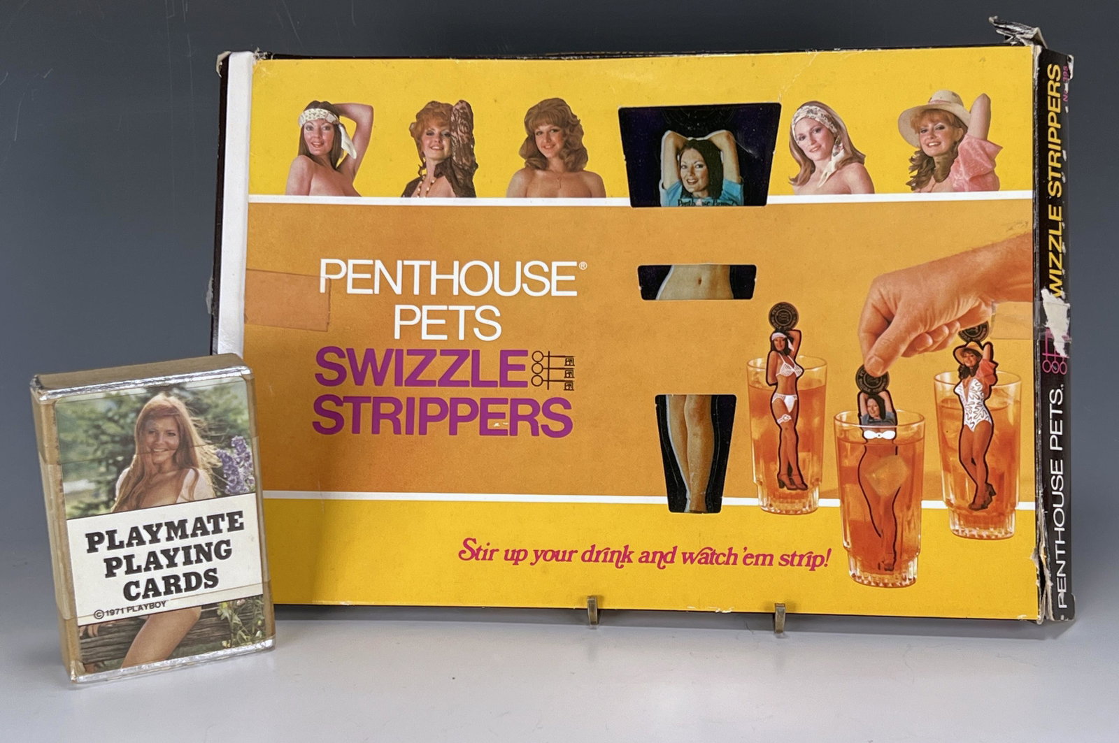 PLAYBOY AND PENTHOUSE LOT: PLAYBOY AND PENTHOUSE LOT Playboy Playmate playing cards from 1971. Penthouse Pets Swizzle Strippers set in original box. *tape on card case, some damage to swizzle sets due to