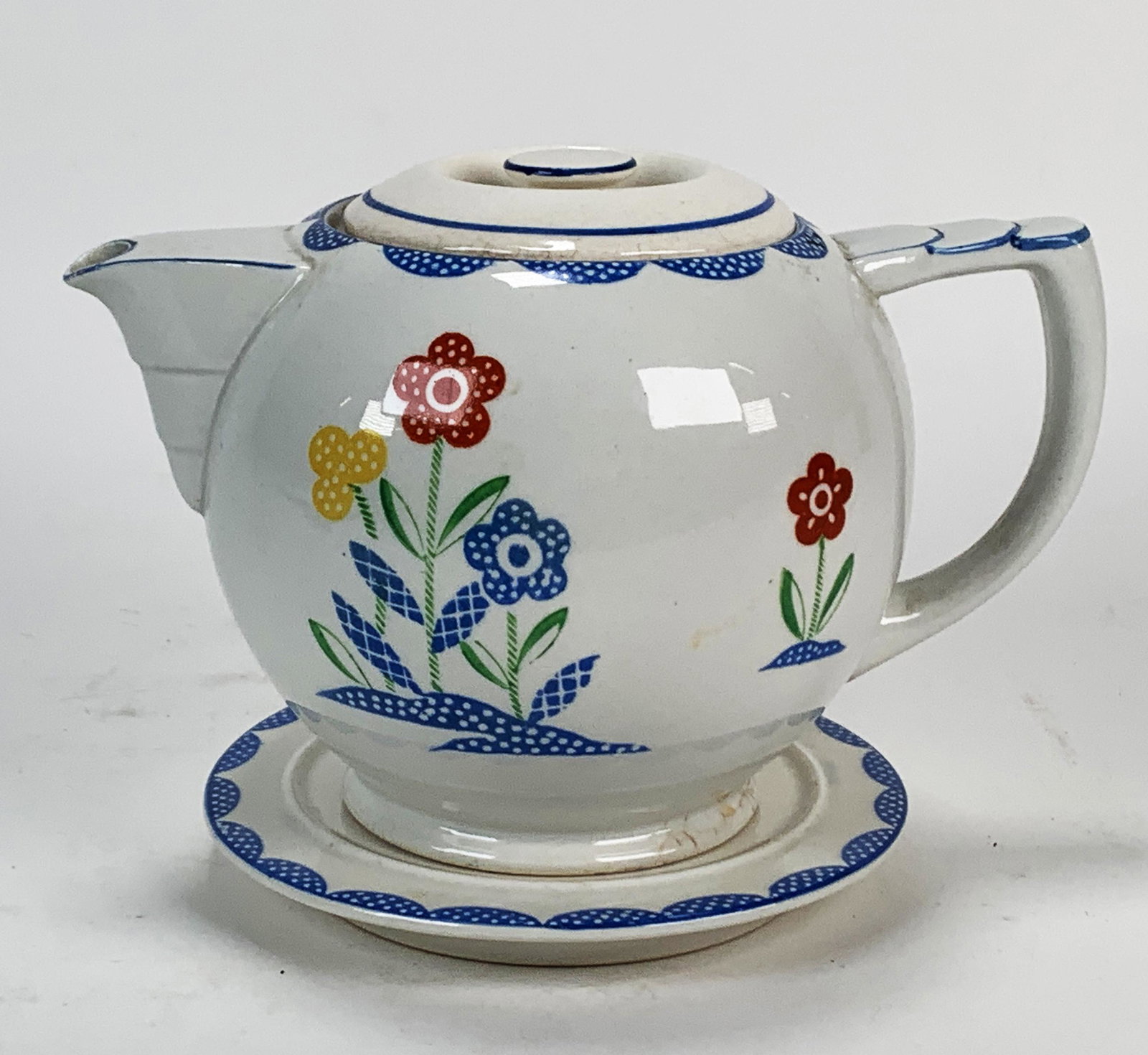 HAND PAINTED FLORAL TEAPOT AND TRIVET: HAND PAINTED FLORAL TEAPOT AND TRIVET Hand painted flower teapot with matching trivet marked made in Japan on bottom. 8 1/2" X 4 1/2"