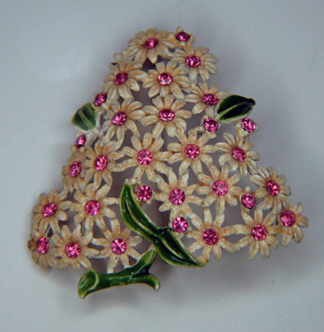 painted or enamel pin: A painted or enamel pin with daisies.