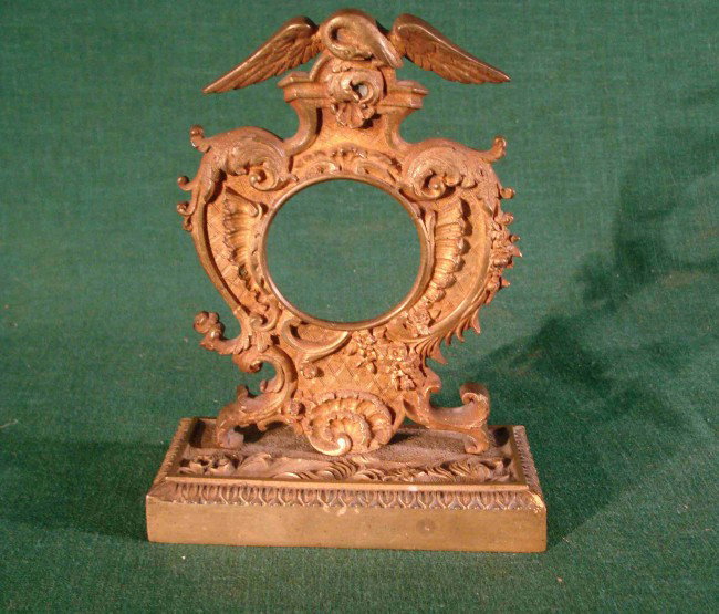 Watch stand: A solid cast brass watch stand of American interest with a cresting to hold the watch and a Federal eagle above.