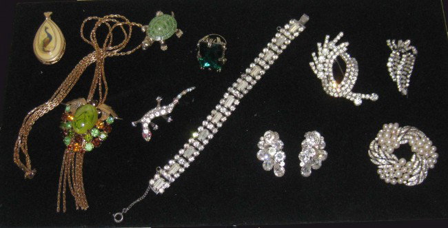 Costume jewelry including Eisenberg earrings: Let a little glitter in your life with an assortment of costume jewelry including a lizard pin, a turtle, and a colorful pendant. Includes Rhinestone earrings signed Eisenberg.