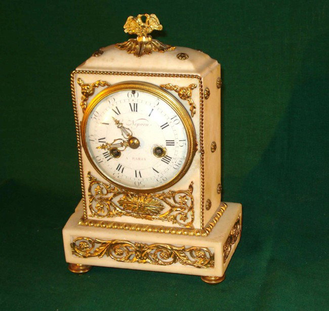French white marble clock: A white marble and ormolu decorated French made mantel clock whore porcelain dial is signed Le Nepoeu a Paris, with a silk suspension and count wheel strike,. Ca 1780-1810. Losses and restorations.