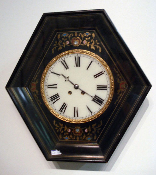 French wall clock: A French made 19th Century wall clock featuring a wood case opening to a dial with white applied cartouche numerals. Strikes on a gong.