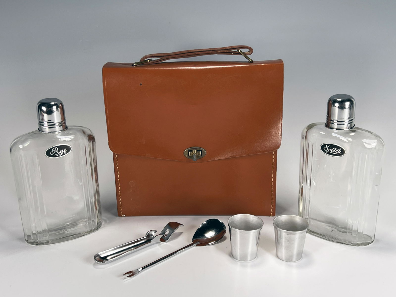 TRAVEL BAR IN LEATHER CASE: TRAVEL BAR IN LEATHER CASE Always be prepared! A bar for people on the go with flasks, jiggers, and stirrers in a leather carry bag. 9" X 8 1/2"<
