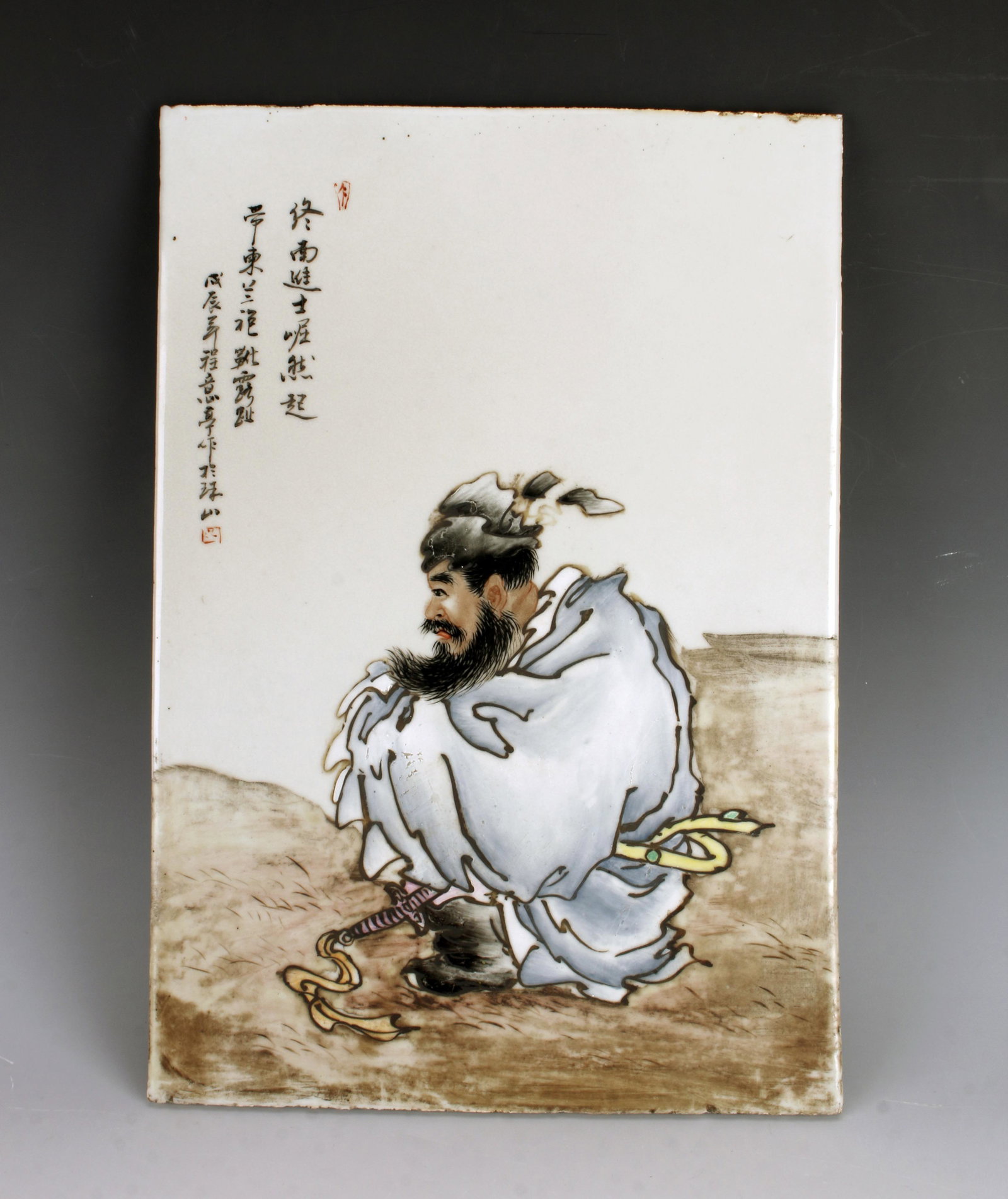 CHINESE PORCELAIN PLAQUE OF SEATED MAN: CHINESE PORCELAIN PLAQUE OF SEATED MAN Dramatic portrayal of a seated man. You can see the hilt of his sword peeking from his robes. He has a full beard. Calligraphy and artist marks on