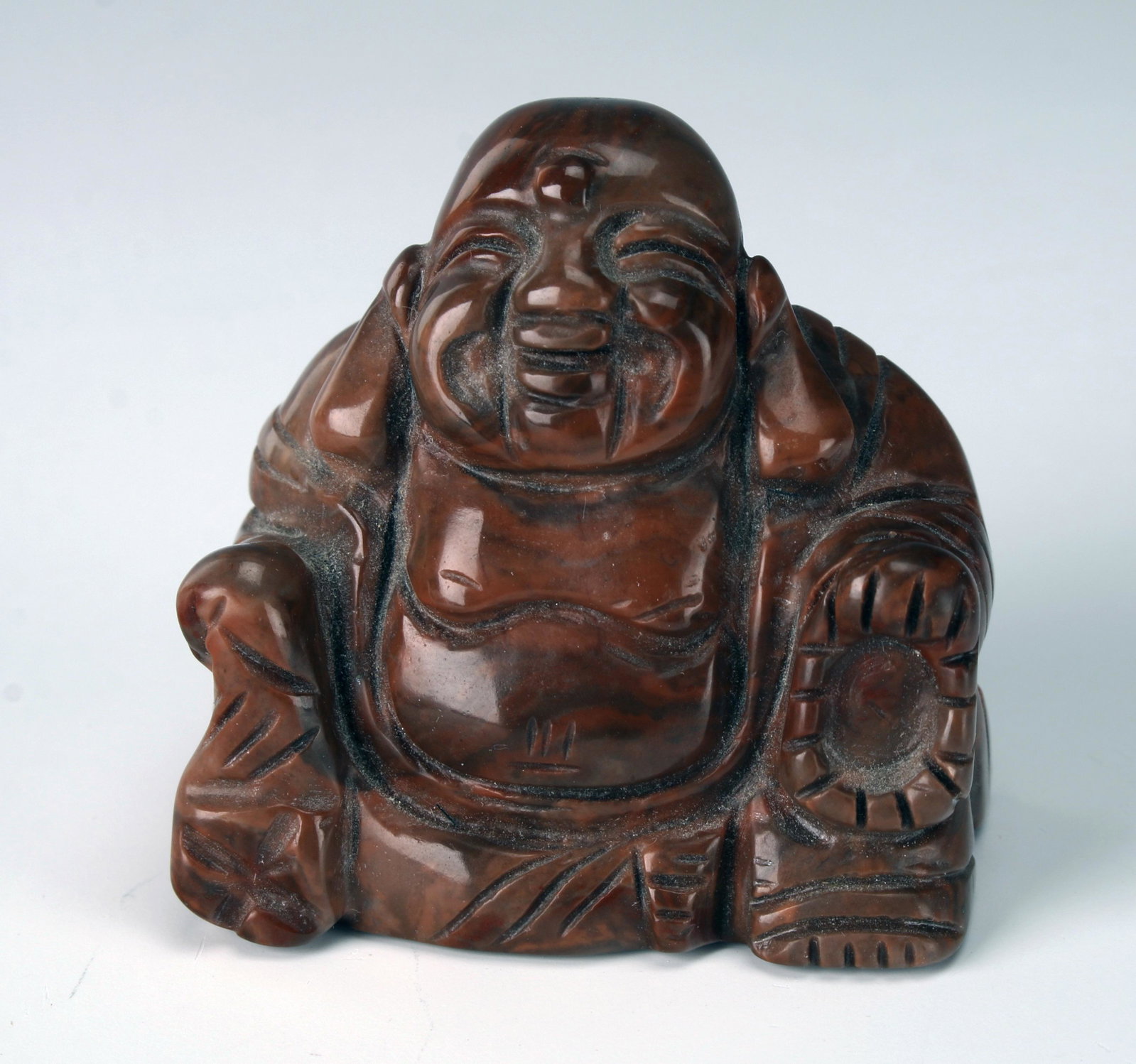 STONE BUDDHA STATUETTE: STONE BUDDHA STATUETTE The Buddha is seated with his hands on his knees. He has a happy face and elongated earlobes. 2" X1 3/4"