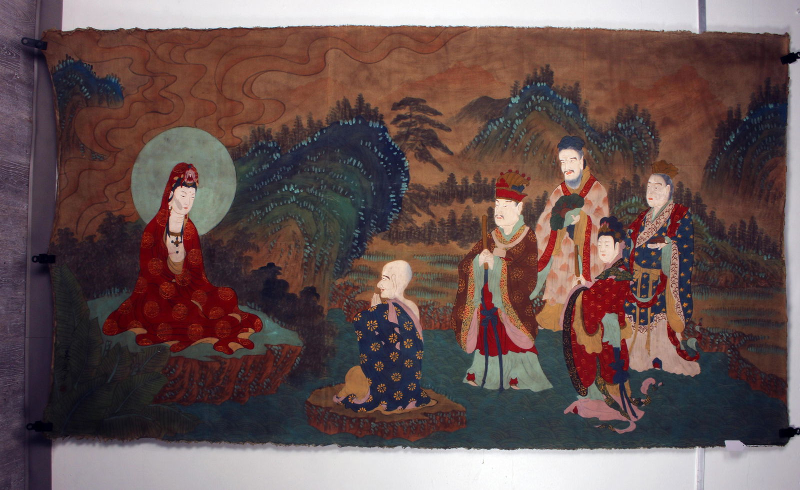 LARGE CHINESE THANGKA PAINTING OF BUDDHA & IMMORTALS: LARGE CHINESE THANGKA PAINTING OF BUDDHA & IMMORTALS Buddha is sitting in robes accented in gold and is seated in the lo