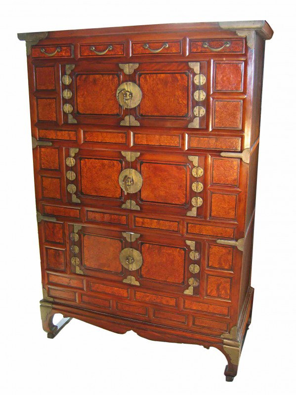 Korean Chest: A two piece chest with the top section in panels and with three locks for cabinet doors all standing on a short legged base.