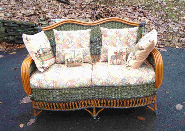 Wicker Settee Set: Matching set of wicker: an upholstered settee with seat cushions and occasional cushions; a matching round top table and demi-lune side table. Tables with fitted glass tops.