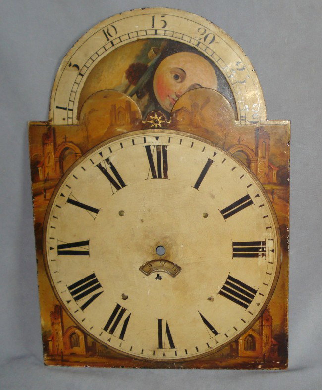 Clock Dial With Moon Phase: A broke arch type 19th century enamel dial from a grandfather clock, including the moving moon device and calendar disk. 18 1/2" X 13 1/8".