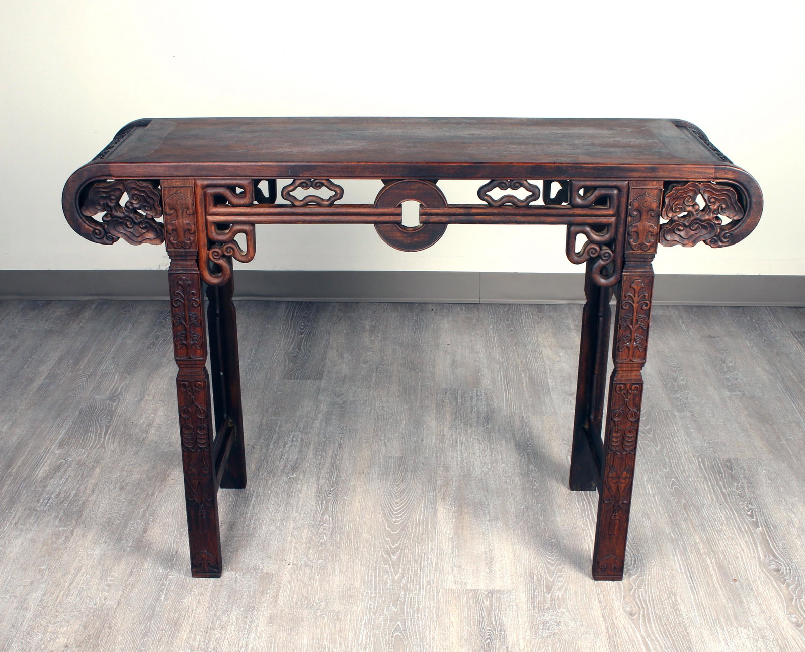 CHINESE HUANGHUALI CARVED & PIERCED PAINTING TABLE: CHINESE HUANGHUALI CARVED & PIERCED PAINTING TABLE Painting table with curved edges. Lucky coin in the center of the apron. Carved and pierced fan and serpentine shapes. Legs are car