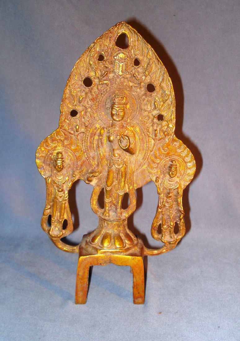 18th Century Cast Buddha: A Buddha figure flanked by two others , all set upon a four legged stand.