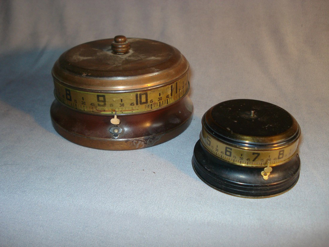 Collectable "Tape Measure" Desk Clocks: Two collectable 20th century clocks often called tape measure clocks but with annular dials with one indicator to tell the time. Both with imperfections and wear.
