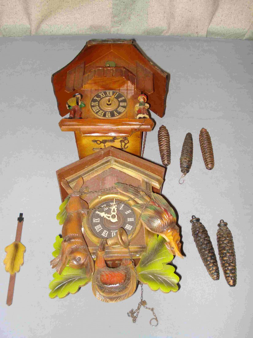 Two Three Weight Cuckoos: Two 20th century cuckoo of Black Forest clocks. One, in the Chalet form, with three weights equipped with a music box; the other with two weights.
