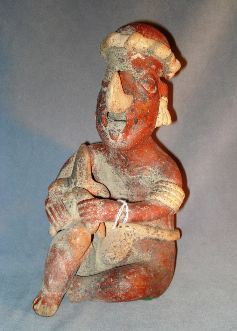 Pre Colombian Style Terra Cotta Idol: A replica of a pre-Colombian statue of South American origin. There is a hole on the top of his head which could be for a candle. About 9" in height.