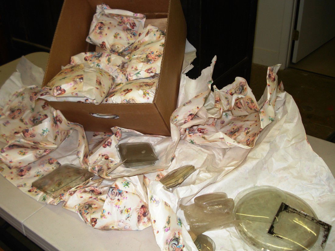 Clock Glasses: A box full of packets of curved and specially made glasses for vintage clocks. Most packets contain several glasses. Many different sizes.
