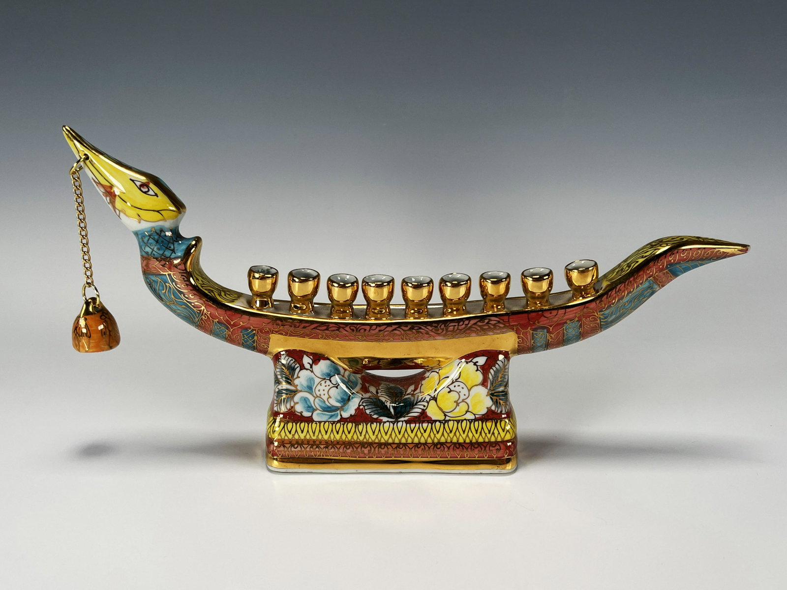 LUSTER HANUKAH MENORAH: LUSTER HANUKAH MENORAH In the form of a dragon boat and with hanging candle snuffer. 12" X 6" Shipping: