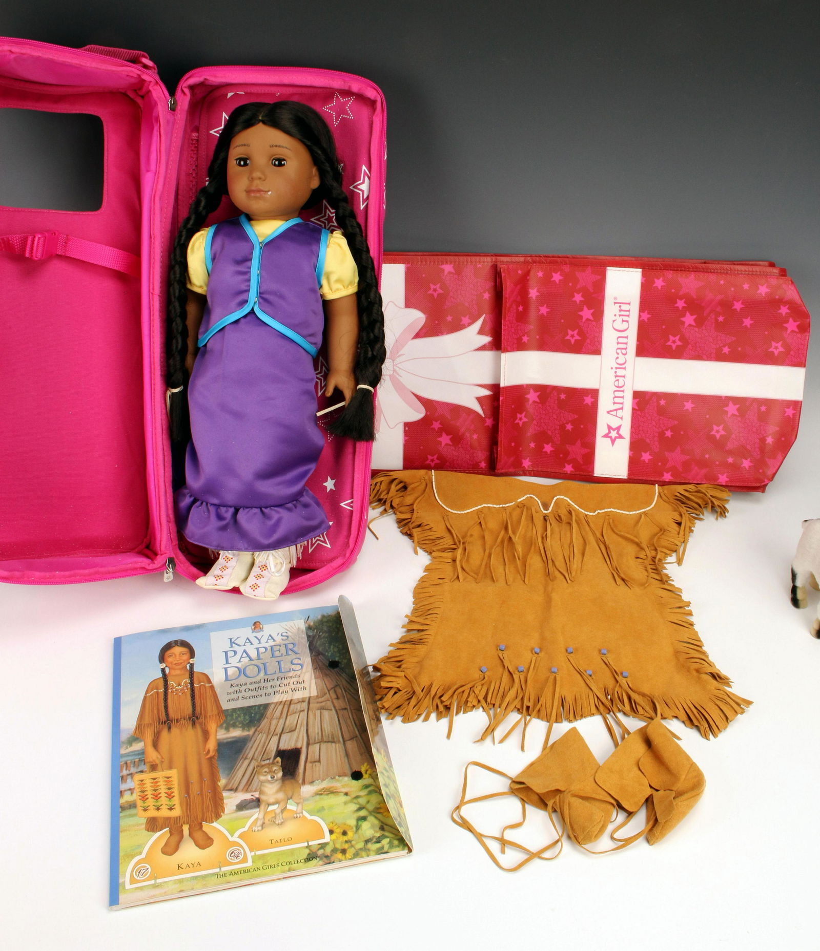 AMERICAN GIRL KAYA LOT: AMERICAN GIRL KAYA LOT Contains Kaya doll in an American Girl storage case, paper doll book, Kaya's Celebrations and Jingle Dress of Today outfits, additional clothing and a goat.