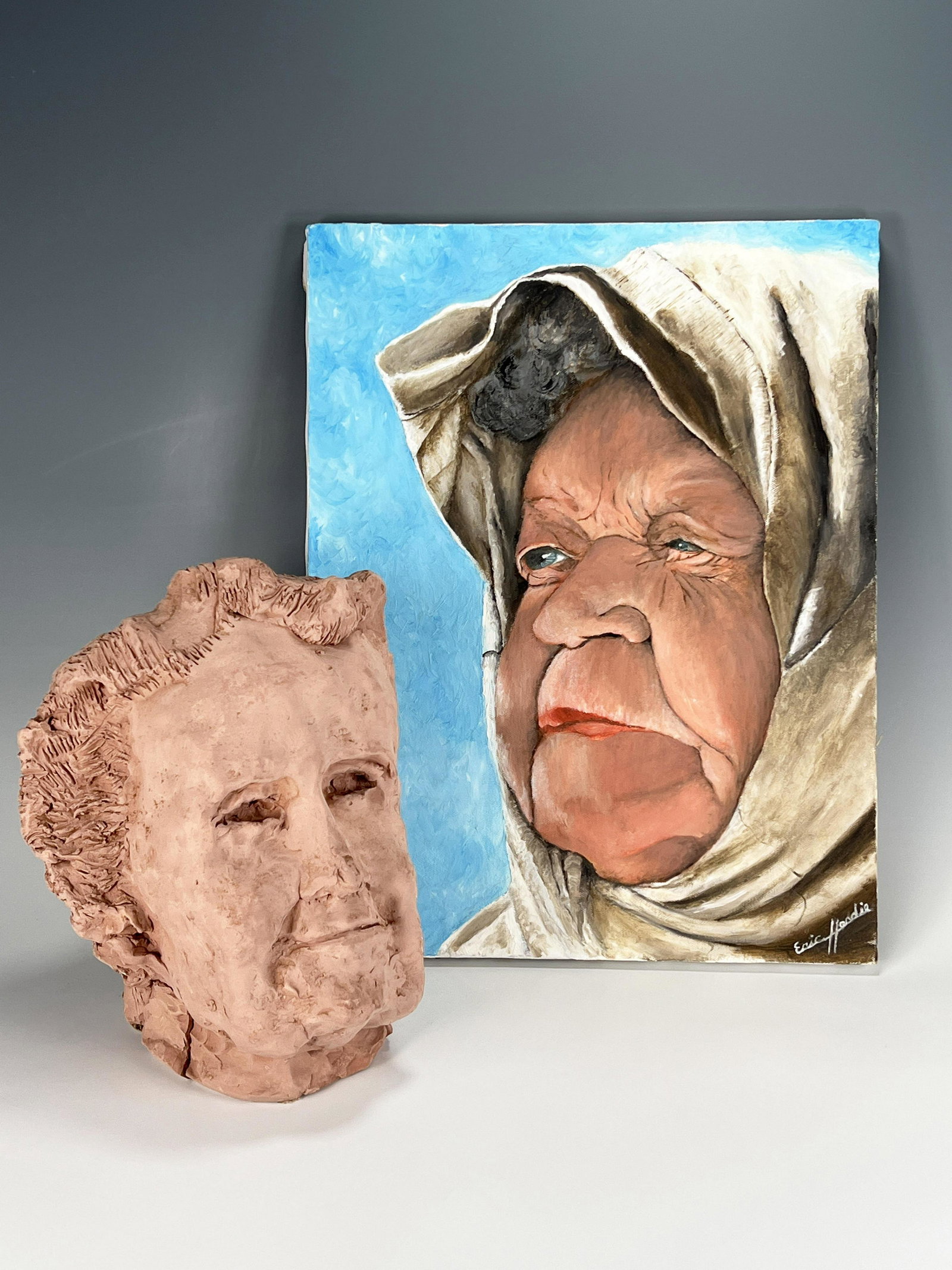 TWO FOLK ART ITEMS: TWO FOLK ART ITEMS Includes signed painting of elderly woman and sculpture of head. 18" x 14" Shipping: