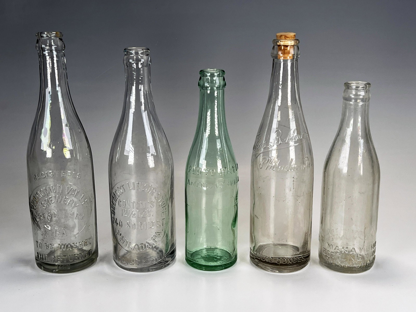 VINTAGE CLEAR GLASS BEVERAGE BOTTLES: VINTAGE CLEAR GLASS BEVERAGE BOTTLES Mayaunk Bottling Works, Pluto Water America's Physic, Belmont Liquor Store, Thos. B. Kane. Perkiomen Valley Brewery. 7
