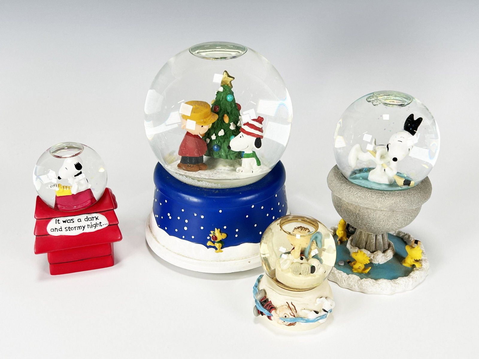 PEANUTS SNOOPY SNOW GLOBES: PEANUTS SNOOPY SNOW GLOBES Snoopy, Woodstock, and Charlie Brown decorate four snow globes in this lot. 6" Shipping: