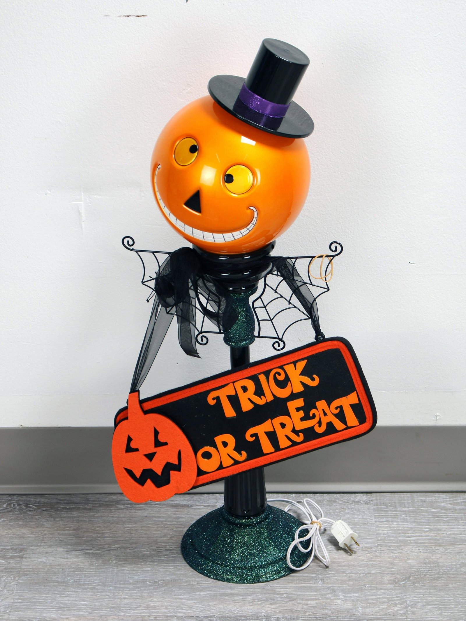 LIGHT UP JACK-O-LANTERN HALLOWEEN DECORATION: LIGHT UP JACK-O-LANTERN HALLOWEEN DECORATION Holding a sign that says "Trick or Treat", the Jack-O-Lantern has a goofy smile and spiderweb collar.