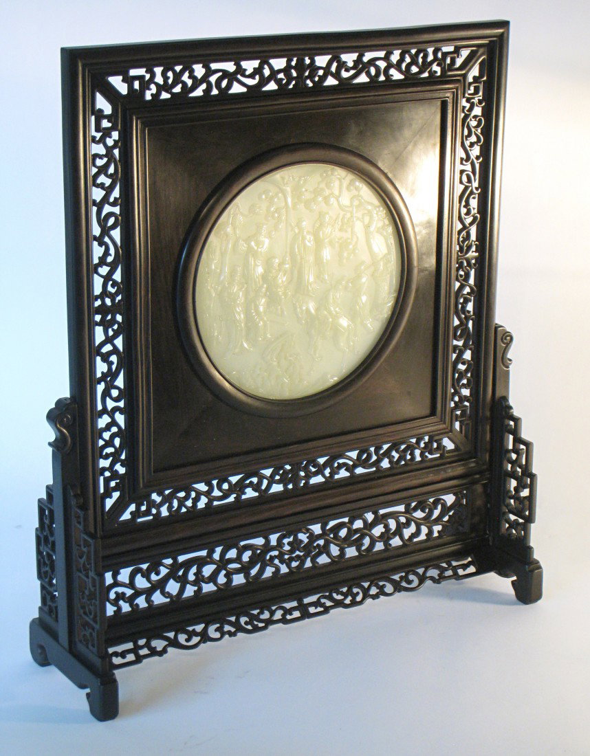 Chinese Table Screen: A rosewood and white jade table screen, the latter being a circular bas relief plaque with eight warrior-like men outdoors. Fine translucent jade and carving. 171/2" X 15 1/2".