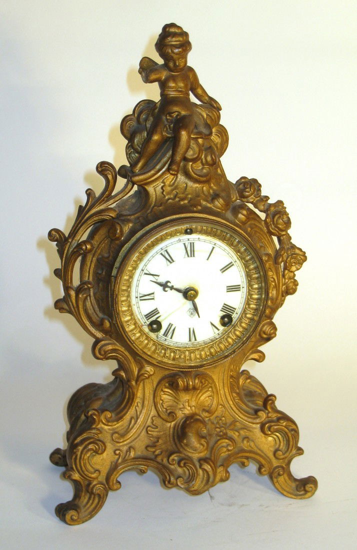 Ansonia Mantel Clock: A 13" Louis XIV style gilded metal cased mantel clock by Ansonia. Probably dates between 1880 and 1910. The putti missing one hand. About 12" in height.