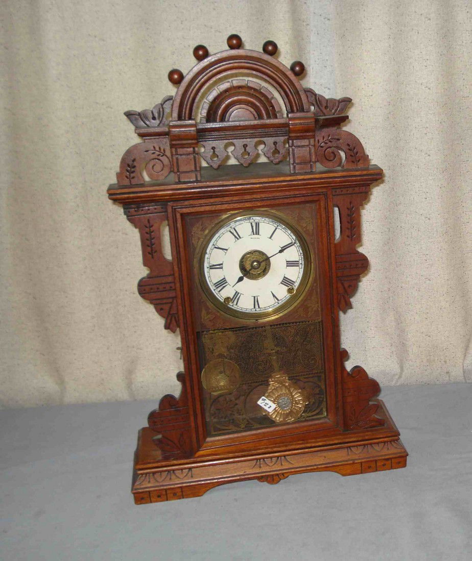 Seth Thomas Eclipse Shelf Clock: A walnut carved and incised mantel clock by the Seth Thomas Clock Company , model "Eclipse". 24 1/2" high, 156 1/2" long. Restored dial.