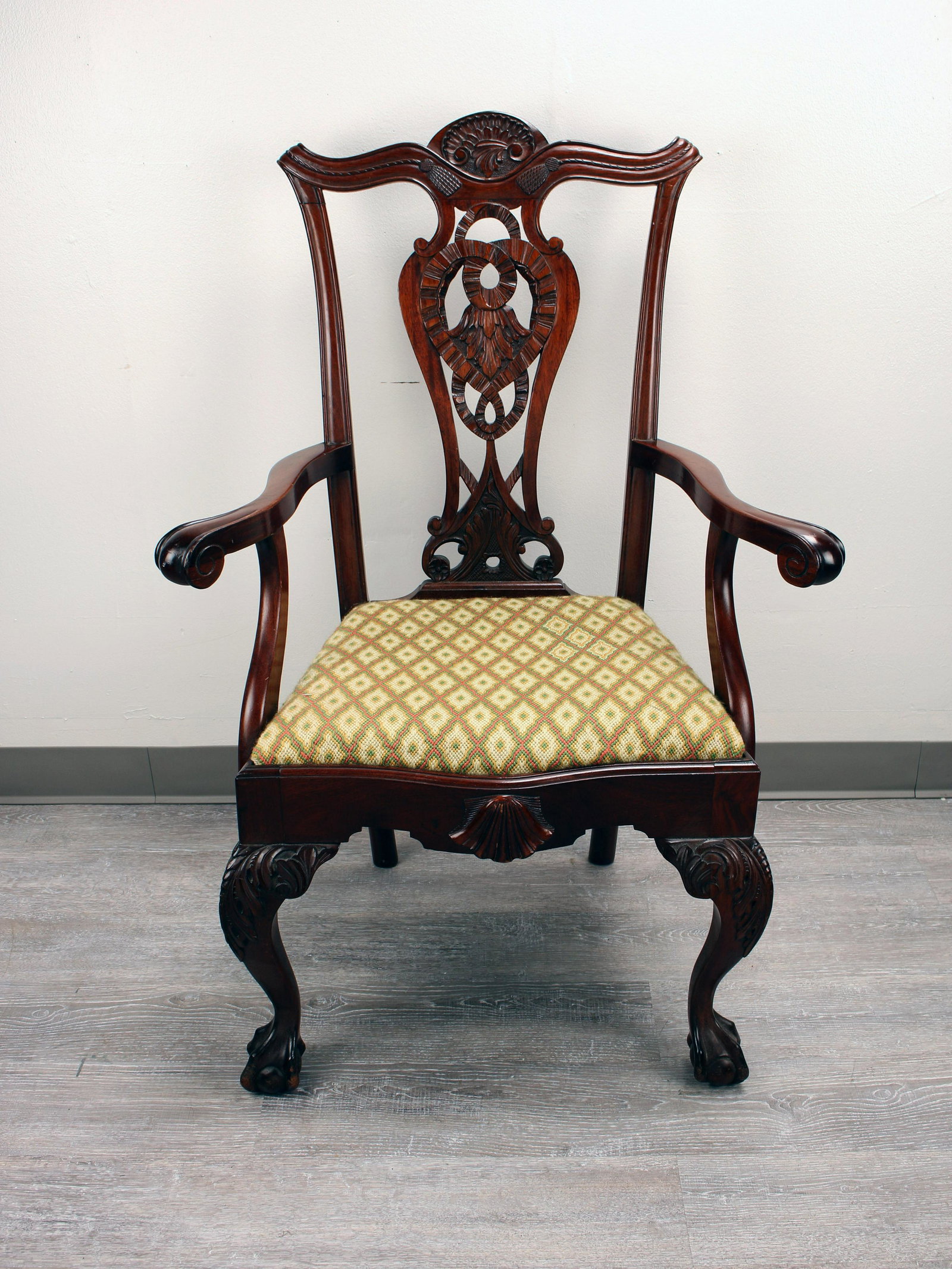 CHIPPENDALE STYLE CARVED ARMCHAIR: CHIPPENDALE STYLE CARVED ARMCHAIR Chippendale style armchair with primarily yellow upholstery with green, red, and gold accents. 40" x 28" x 20&qu