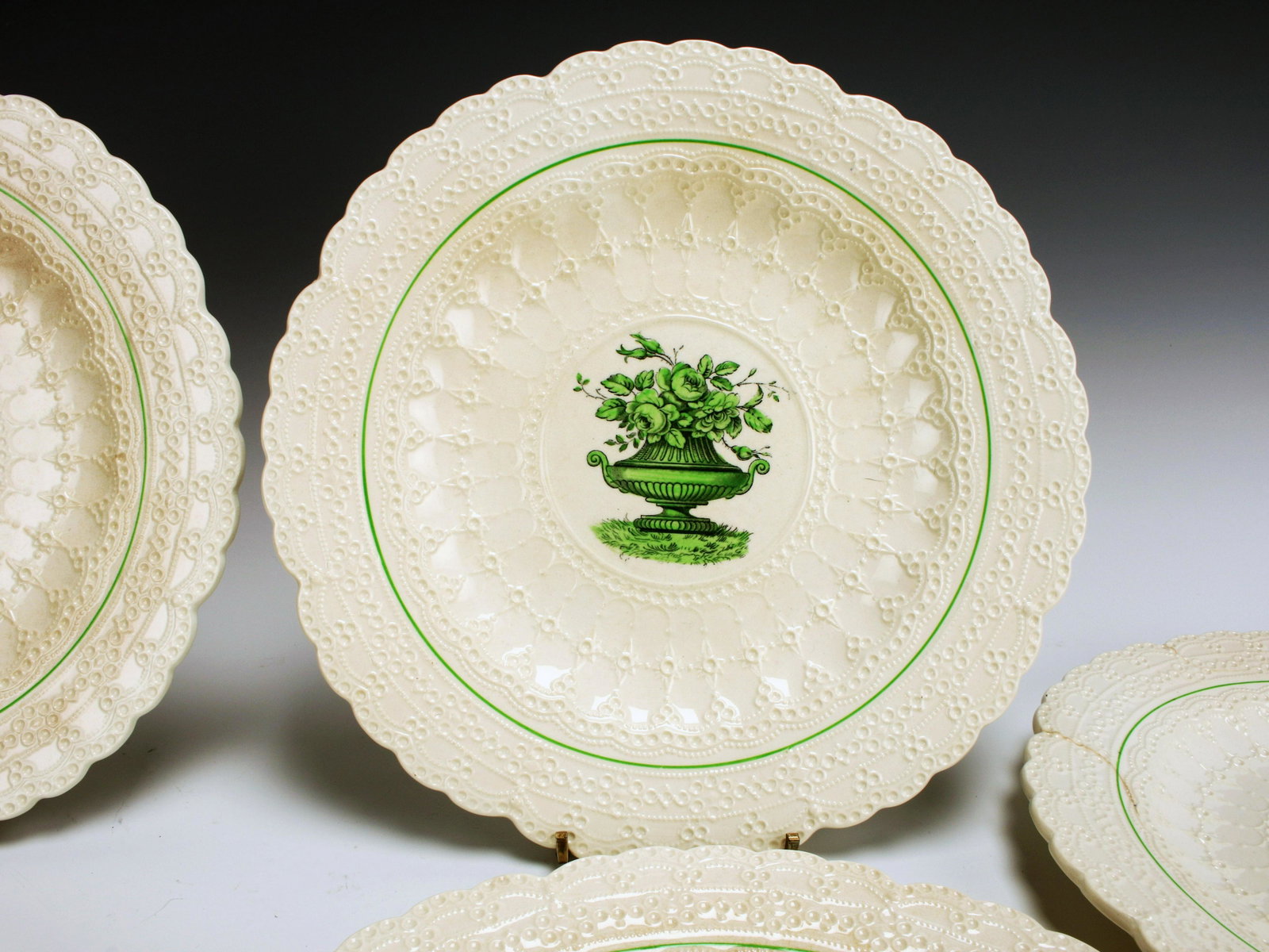 SIX ENGLISH SPODES JEWEL COPLAND PLATES: SIX ENGLISH SPODES JEWEL COPLAND PLATES Cream embossed plates with green garden urn in centers. One plate with hairline cracks. 9 1/4"