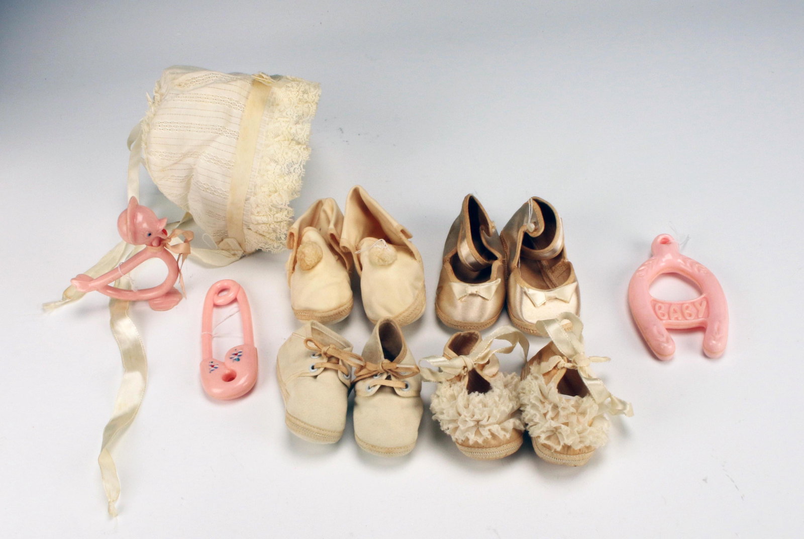 VINTAGE BABY SHOES TOYS BONNET: VINTAGE BABY SHOES TOYS BONNET Pink plastic baby toys, bonnet, four pairs of shoes. One pair of shoes is marked Mrs. Day's Baby Ideal Shoes size 1. Some stains on bonnet.