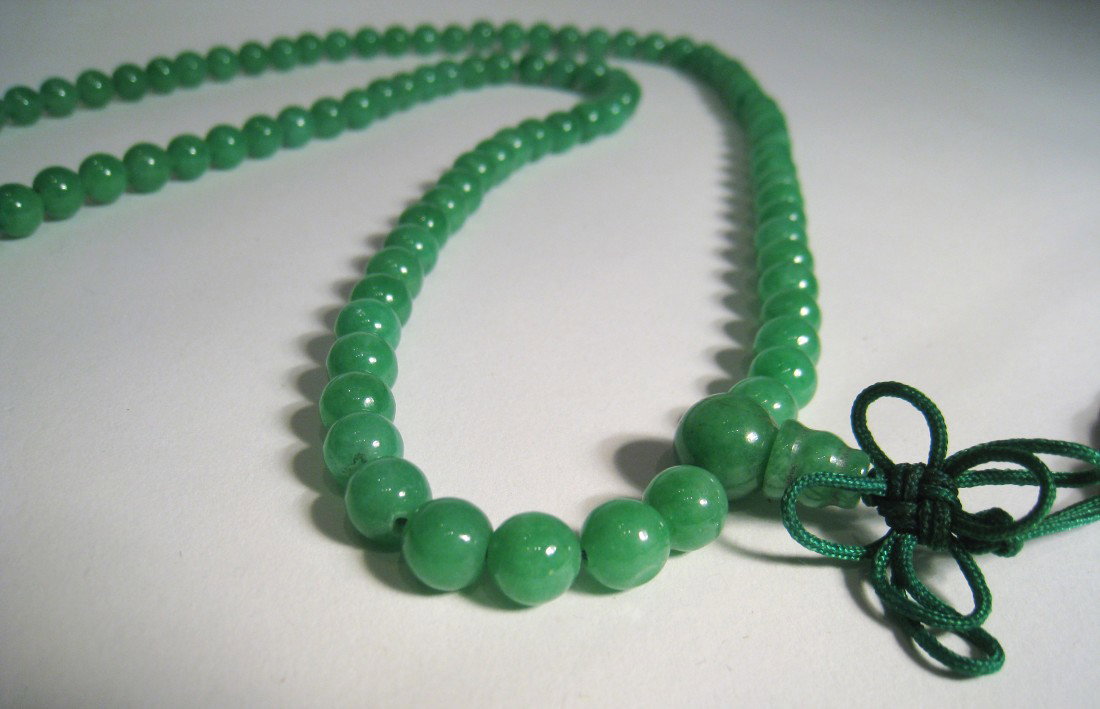 Light Green Jade Necklace: A 16" beaded necklace with 1/4" beads and a tassel form knotted green pendant string.