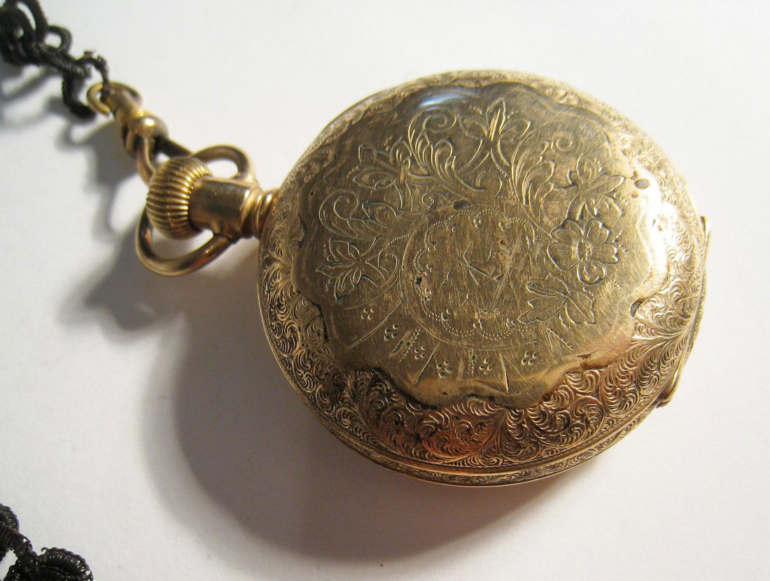 An Elgin Watch With A Hair Link Chain: A gold filled watch by Elgin in a hunting case with a watch chain attached made from black hair. (The chain is very fragile).